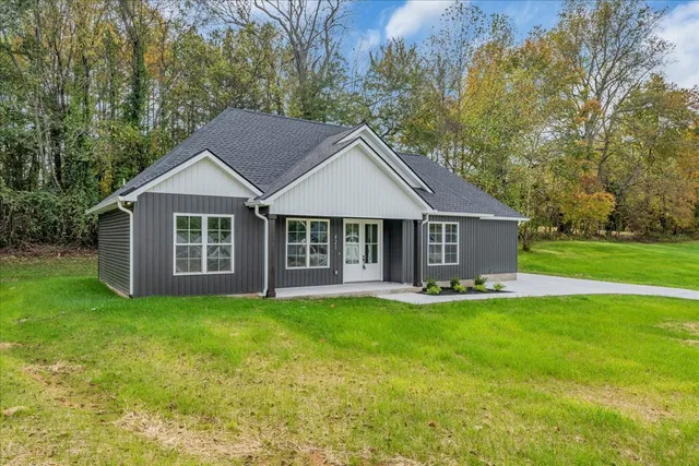 a front view of a house with a garden and trees