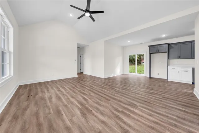 a view of empty room with wooden floor and window