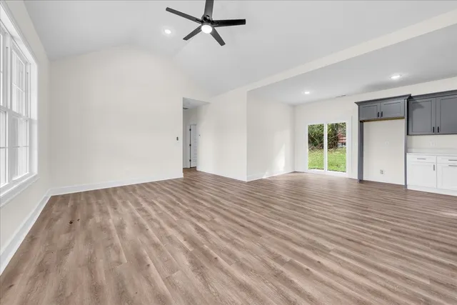 a view of empty room with wooden floor and window