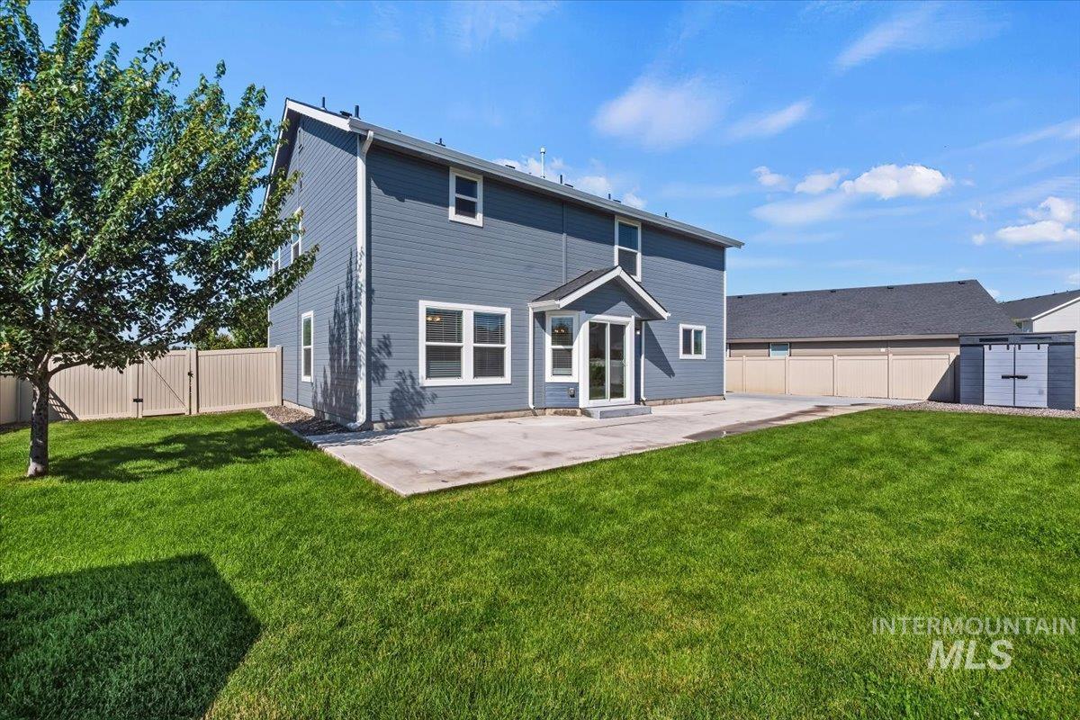 12310 West Hidden Point Drive Star, ID 83669 - Photo 42 of 48 Spacious backyard featuring a large concrete patio, expansive lawn, and mature tree
