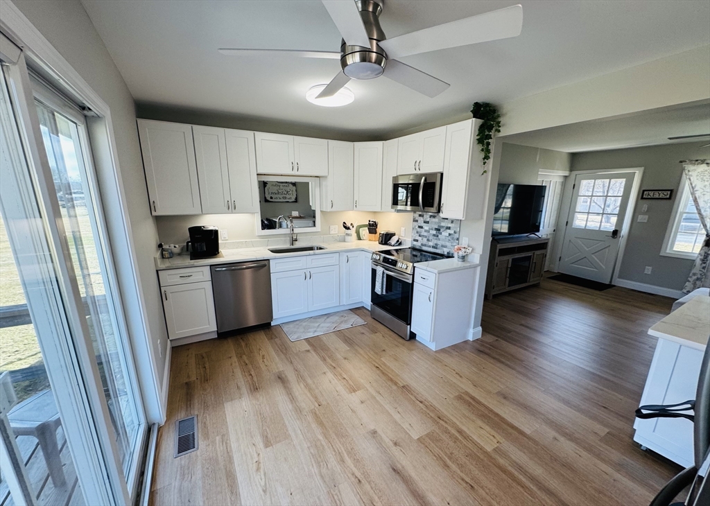 31 Deane Road Bernardston, MA 01337 - Photo 18 of 35 a kitchen with stainless steel appliances granite countertop a stove top oven a sink dishwasher a dining table and chairs with wooden floor