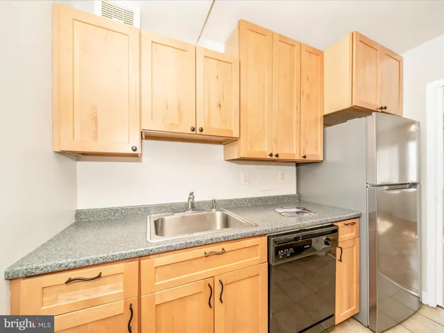 a kitchen with stainless steel appliances granite countertop a sink a refrigerator and a stove