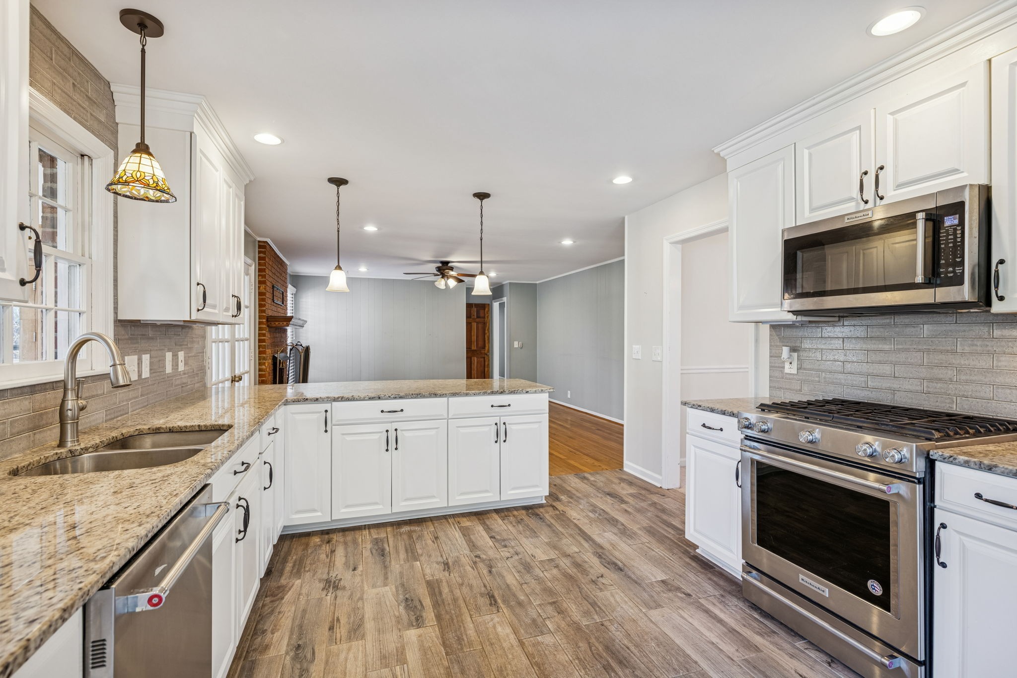 2234 Isaac Lane Franklin, TN 37064 - Photo 28 of 92 a large kitchen with granite countertop a stove top oven a sink dishwasher a dining table and chairs with wooden floor