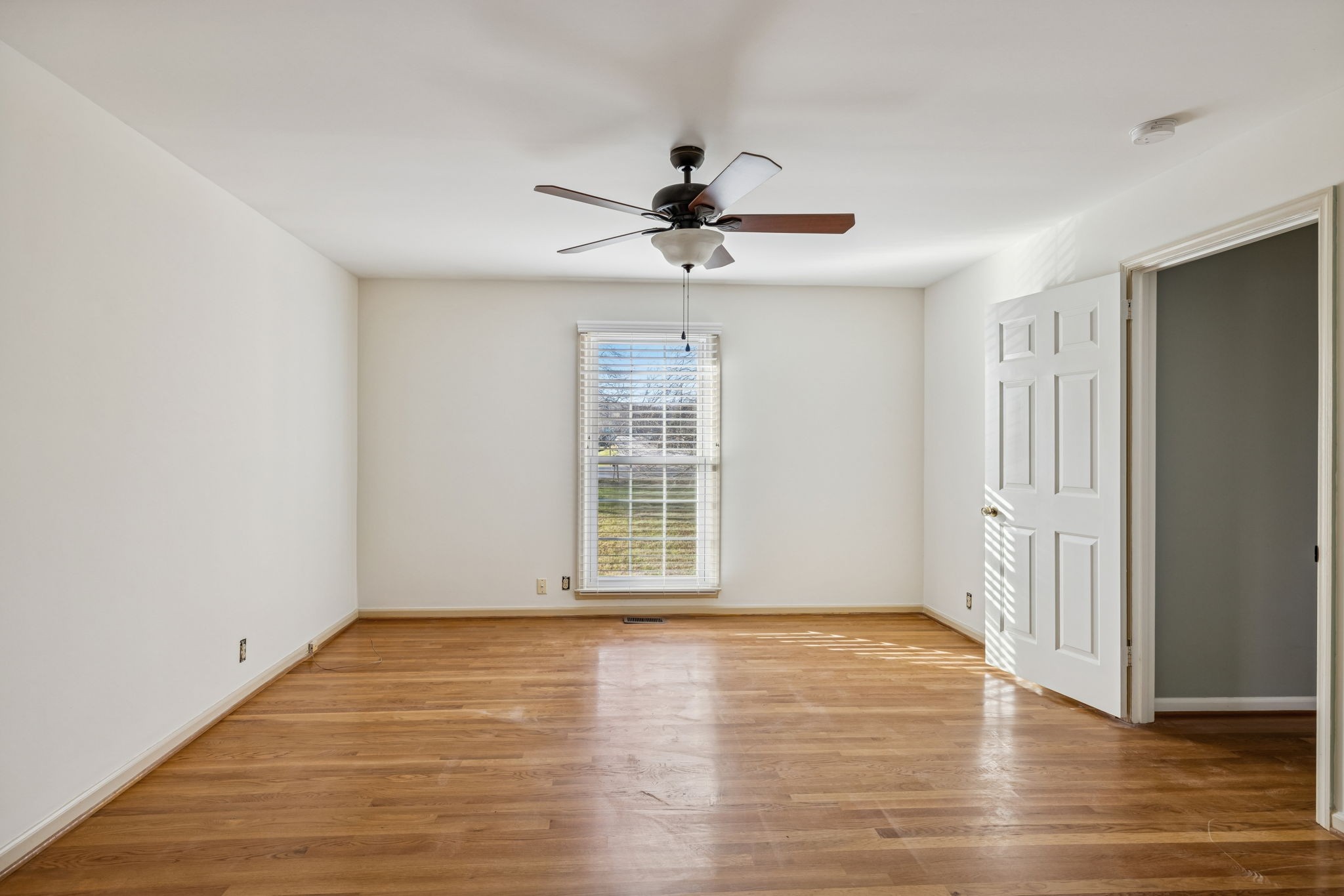 2234 Isaac Lane Franklin, TN 37064 - Photo 43 of 92 an empty room with wooden floor chandelier fan and windows