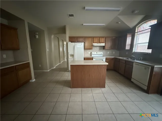 a kitchen with stainless steel appliances granite countertop a refrigerator and a stove