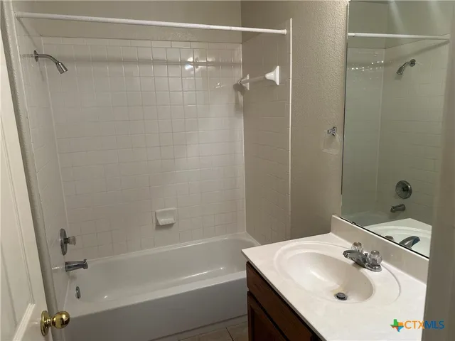 a bathroom with a sink shower and a mirror