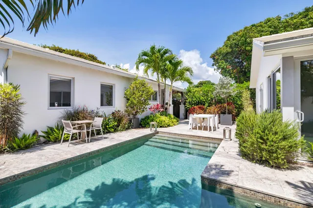 a view of a house with backyard sitting area and garden