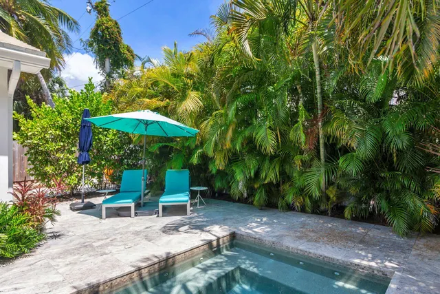 a view of a table and chairs under an umbrella in the garden