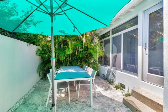 a backyard of a house with plants and outdoor seating