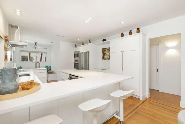 a kitchen with stainless steel appliances kitchen island granite countertop a sink and a refrigerator