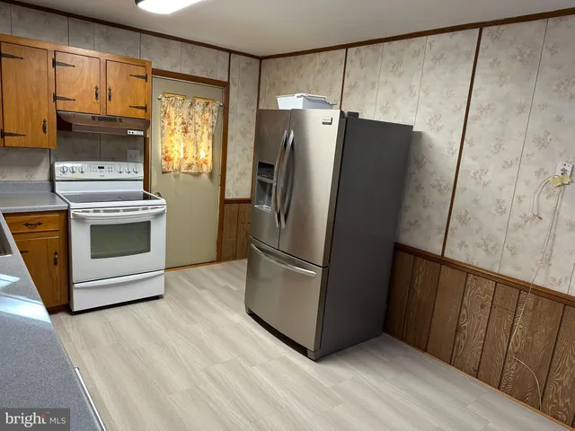 a kitchen with stainless steel appliances a refrigerator and a stove top oven
