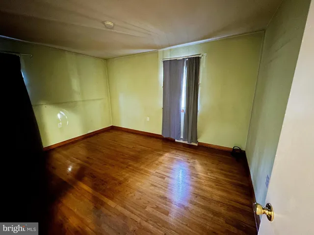 an empty room with wooden floor and closet