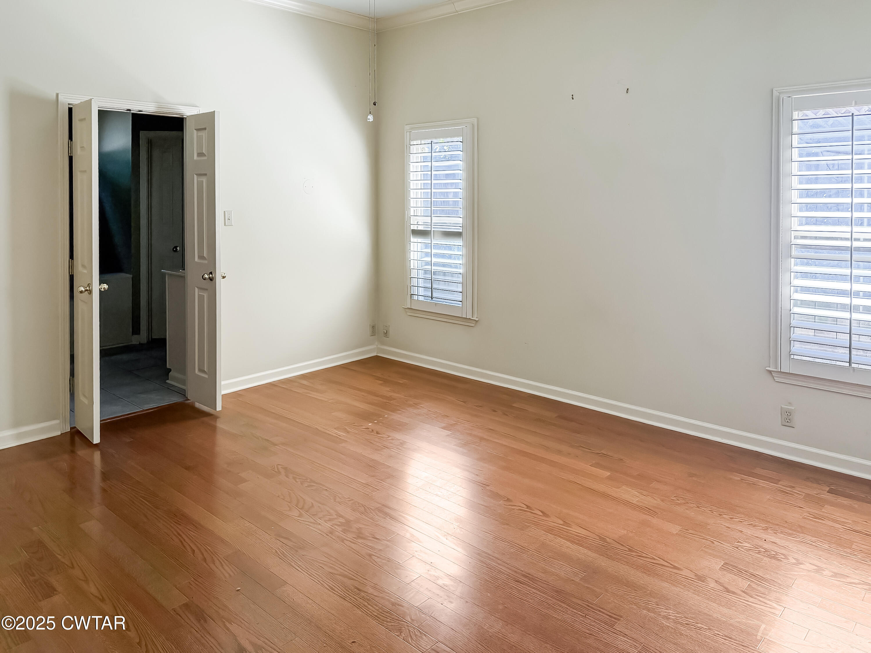 1647 Forsythe Trail Collierville, TN 38017 - Photo 20 of 32 an empty room with wooden floor and windows