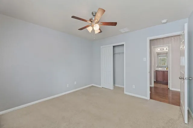 an empty room with closet and a chandelier fan