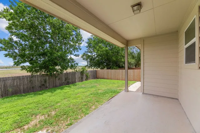 a view of a backyard with wooden fence