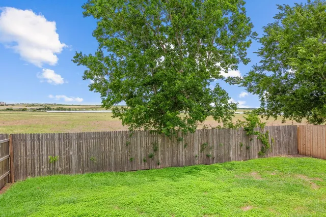 a view of a yard with wooden fence