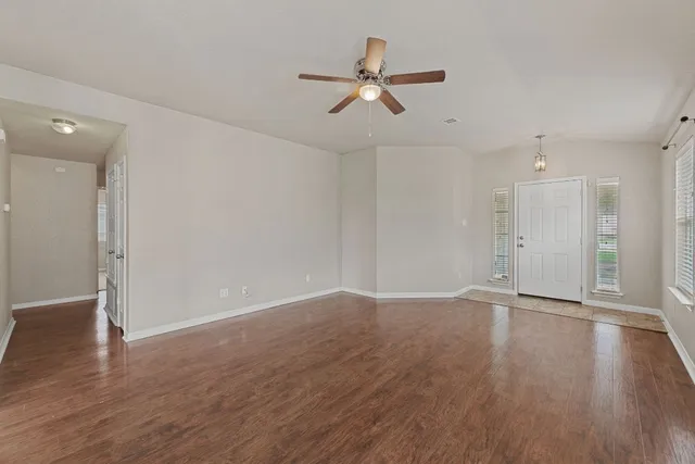 a view of an empty room with wooden floor