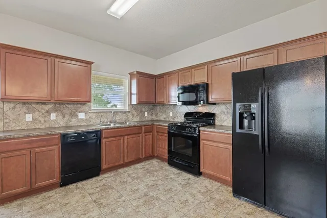 a kitchen with granite countertop stainless steel appliances and wooden cabinets