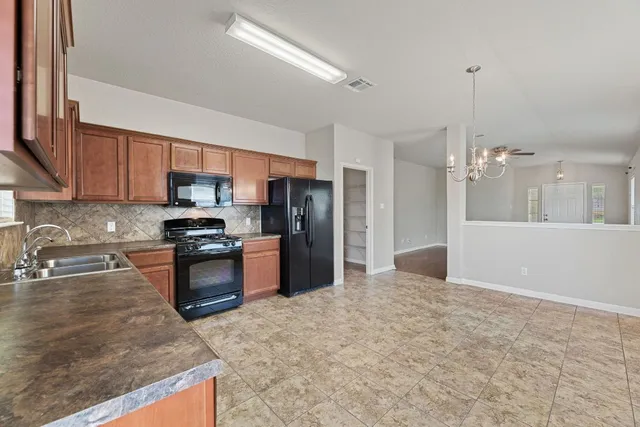 a kitchen with stainless steel appliances granite countertop a refrigerator a stove top oven a sink and dishwasher