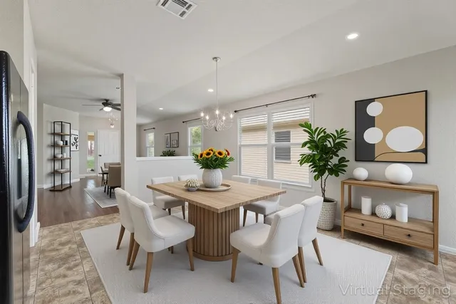 a dining room with furniture and a potted plant