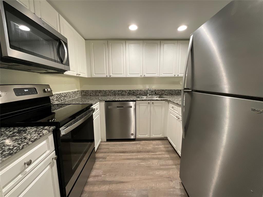 9357 Southwest 77th Avenue, Unit 851032 Miami, FL 33156 - Photo 1 of 17 a kitchen with stainless steel appliances granite countertop a stove a refrigerator and a microwave