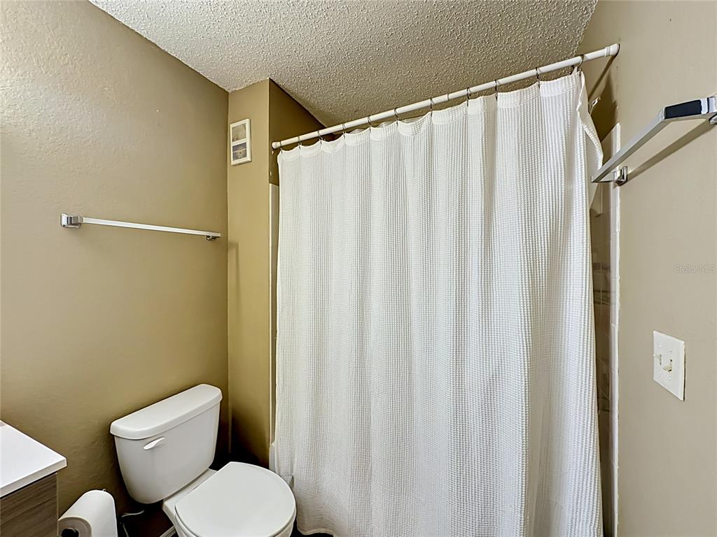 3705 Southwest 27th Street, Unit 922 Gainesville, FL 32608 - Photo 27 of 34 a white toilet sitting next to a shower curtain