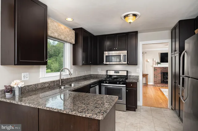 a kitchen with granite countertop a sink stainless steel appliances a counter space and cabinets