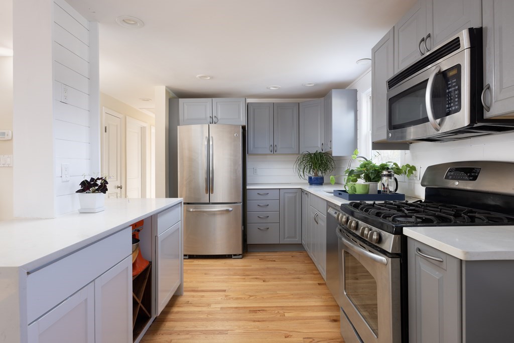 15 Wheaton Road Arlington, MA 02474 - Photo 9 of 19 a kitchen with stainless steel appliances a stove microwave sink refrigerator and cabinets