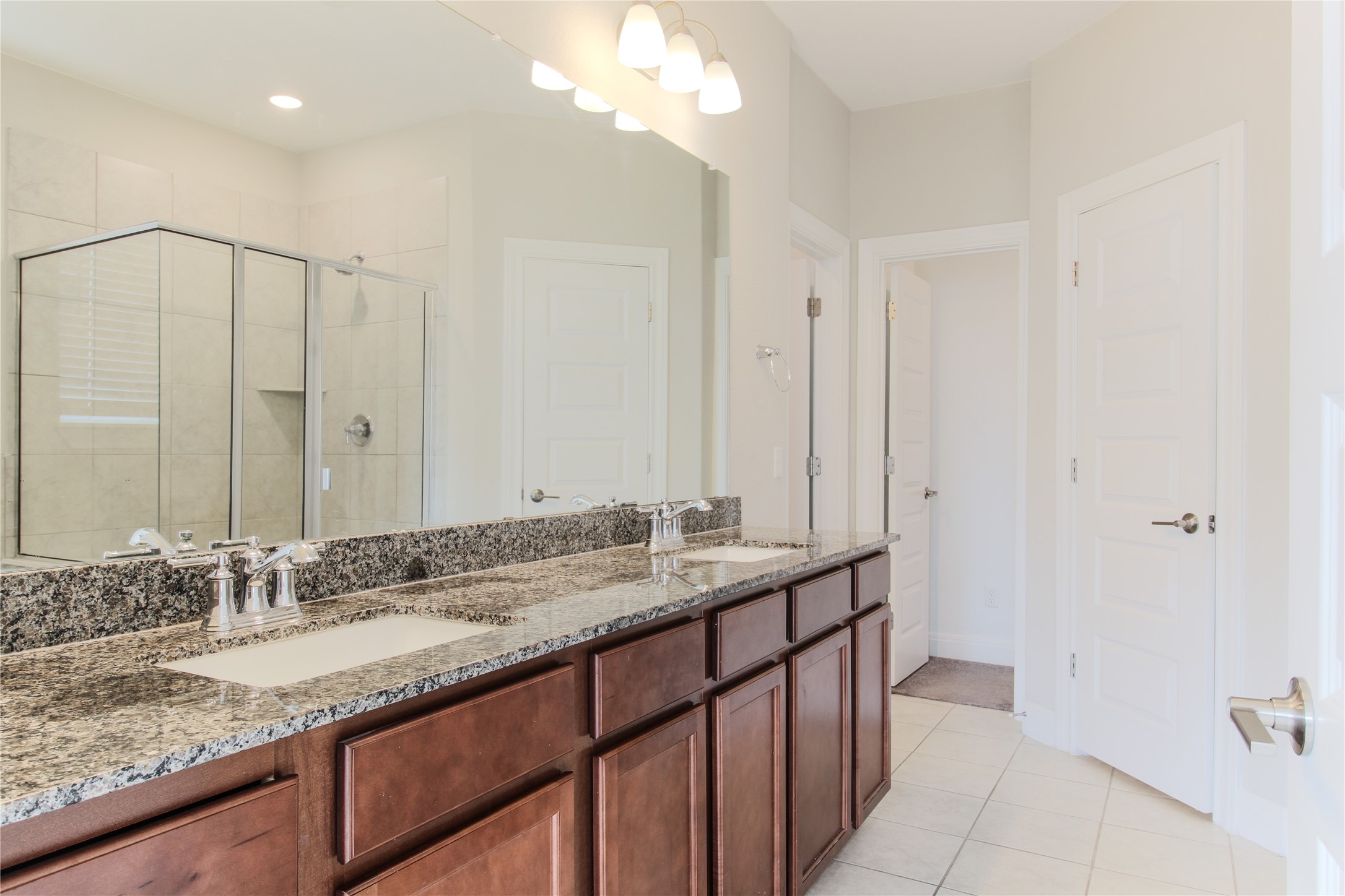 109 Yellow Thistle Cove Georgetown, TX 78626 - Photo 23 of 36 Dual sink vanity with granite countertop, wood-finish cabinetry, and chrome fixtures
