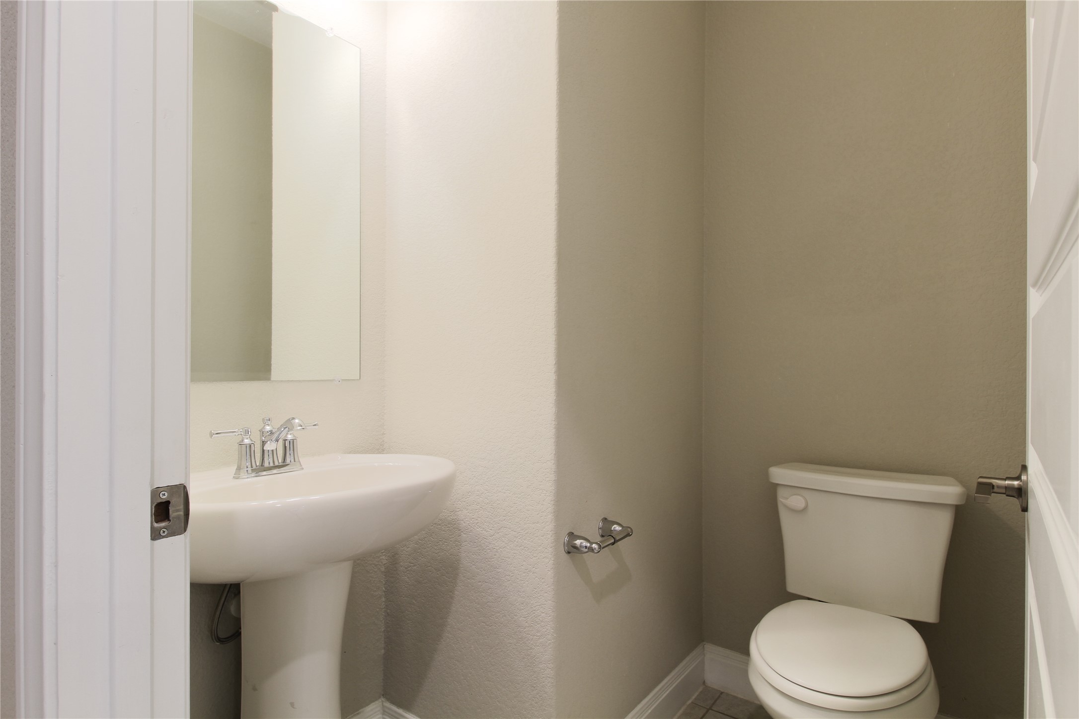 109 Yellow Thistle Cove Georgetown, TX 78626 - Photo 25 of 36 Pedestal sink with chrome faucet, wall-mounted mirror, and white commode