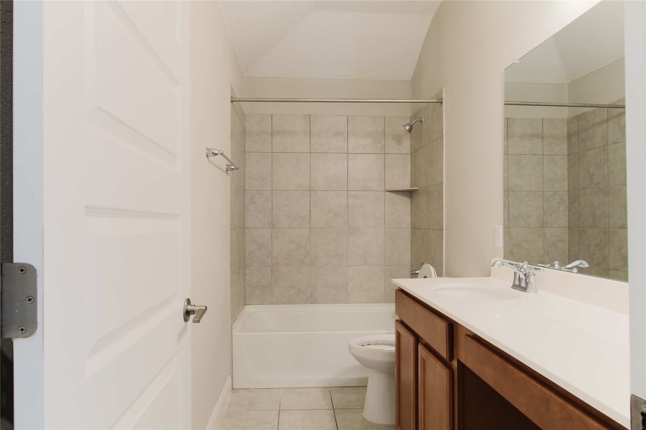 109 Yellow Thistle Cove Georgetown, TX 78626 - Photo 27 of 36 Bathroom featuring a bathtub/shower combination with tiled surround, a built-in shower niche, and a vanity with a white countertop and wood-finish cabinetry