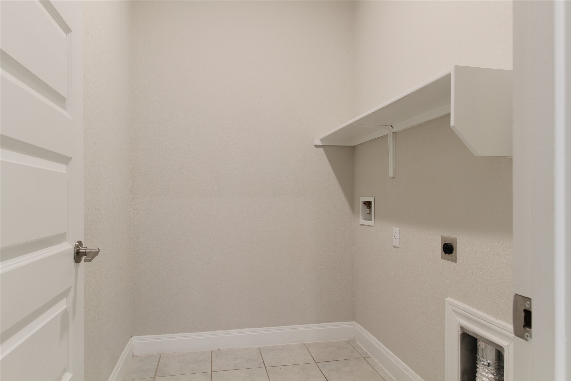 109 Yellow Thistle Cove Georgetown, TX 78626 - Photo 28 of 36 Dedicated laundry area featuring a built-in white shelf, light-colored wall finish, white baseboard trim, and light-toned tile flooring