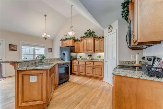 a kitchen with stainless steel appliances granite countertop wooden cabinets stove top oven and sink