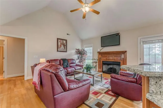 a living room with furniture a fireplace and kitchen view