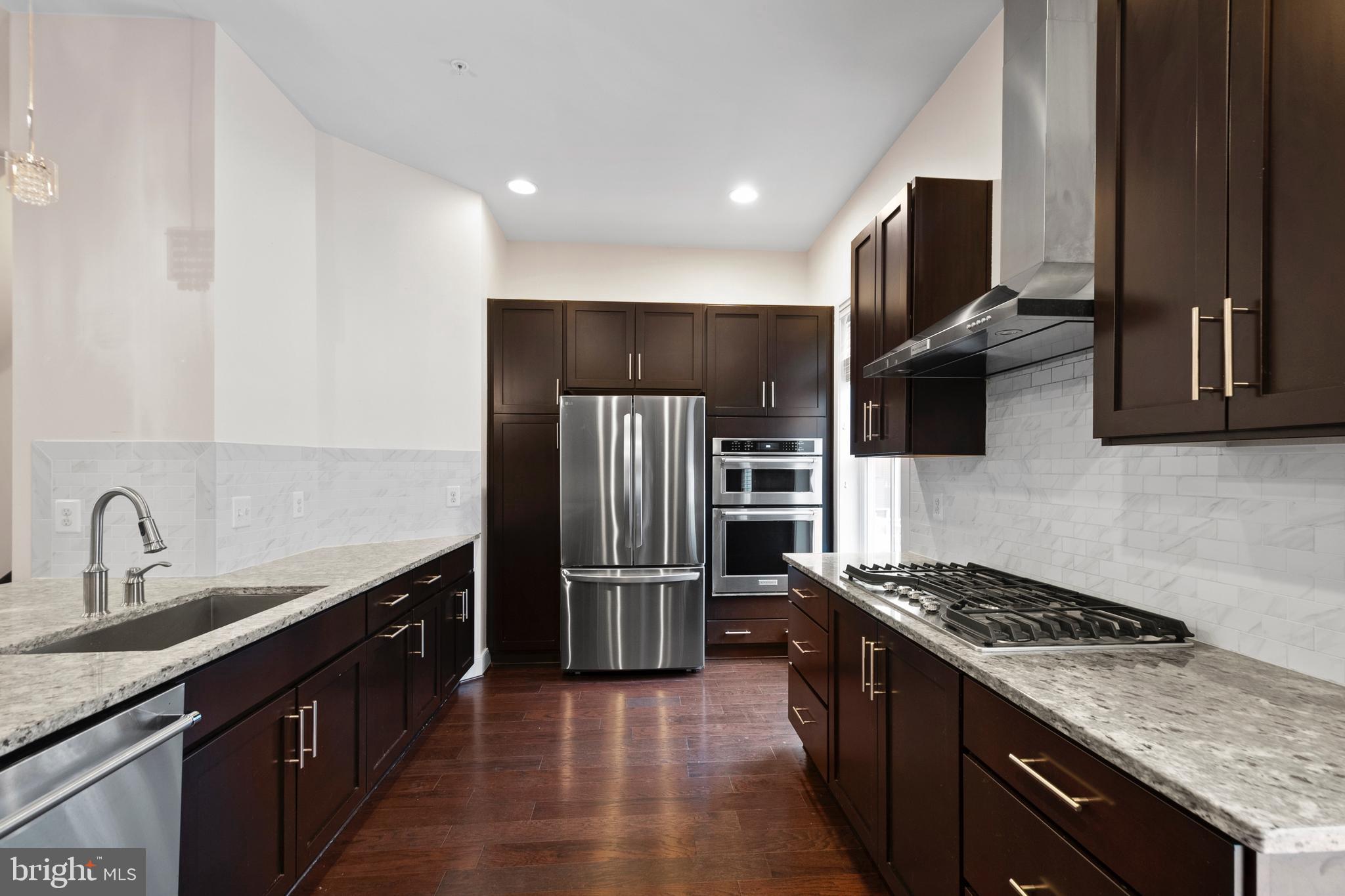 1417 Van Valkenburgh Lane Alexandria, VA 22301 - Photo 16 of 45 a kitchen with kitchen island granite countertop a sink stove and refrigerator