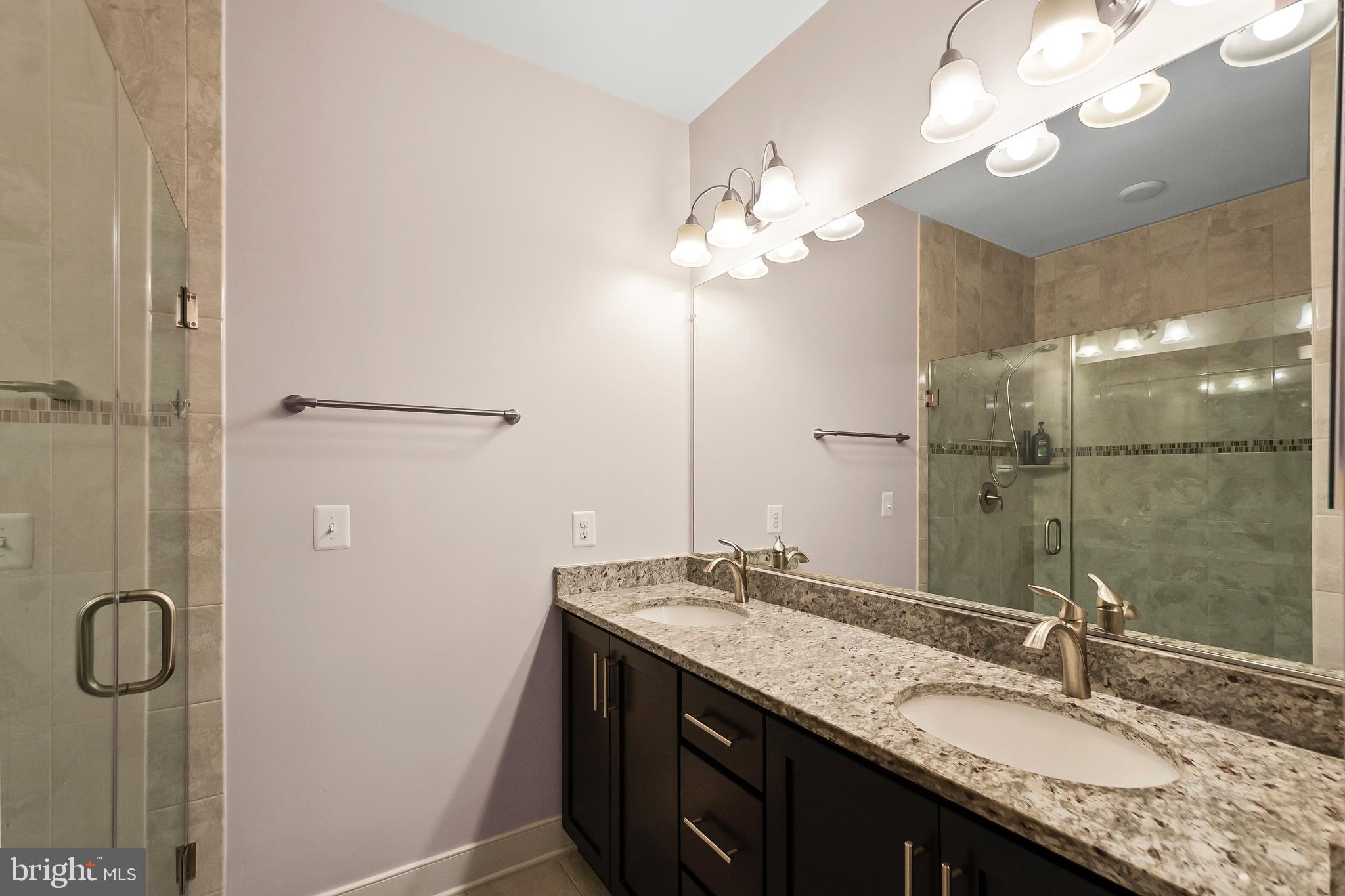 1417 Van Valkenburgh Lane Alexandria, VA 22301 - Photo 29 of 45 a bathroom with a granite countertop sink a large mirror and shower