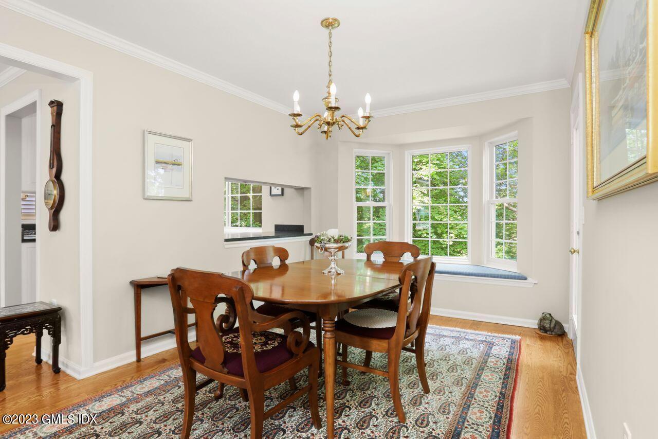 1 Shore Road, Unit 3 Stamford, CT 06902 - Photo 11 of 37 a dining room with furniture a chandelier and wooden floor