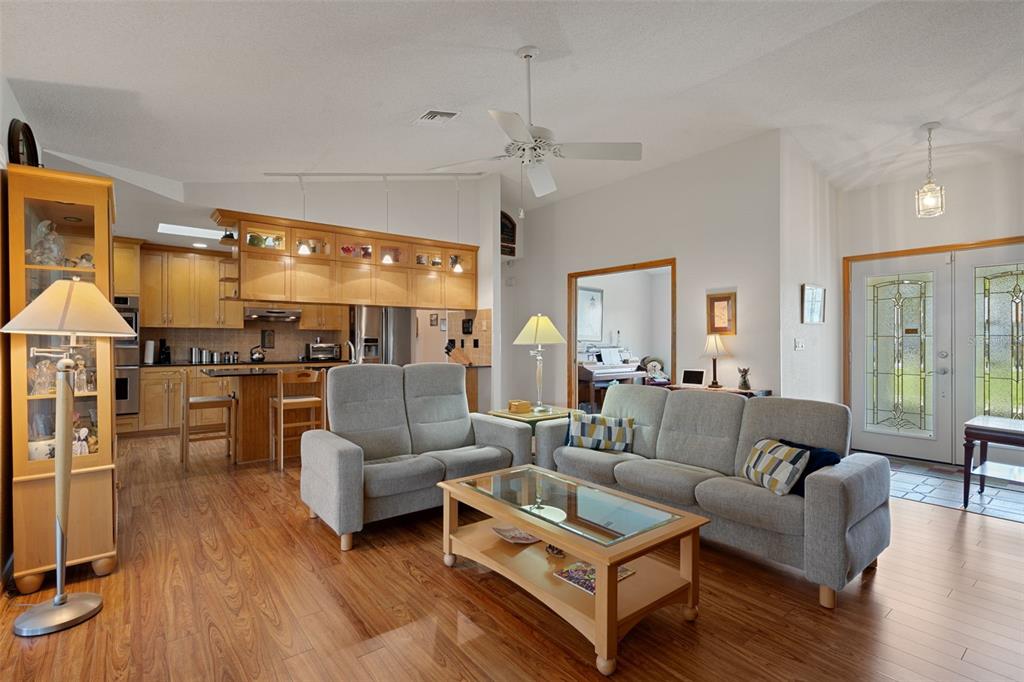 5035 Harbinger Road Spring Hill, FL 34608 - Photo 16 of 47 a living room with furniture kitchen view and a wooden floor