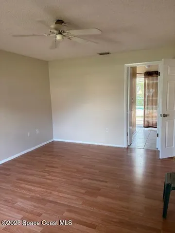 a view of empty room with wooden floor