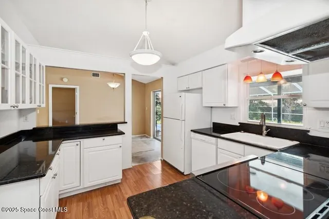 a kitchen with granite countertop a sink a counter top space and appliances