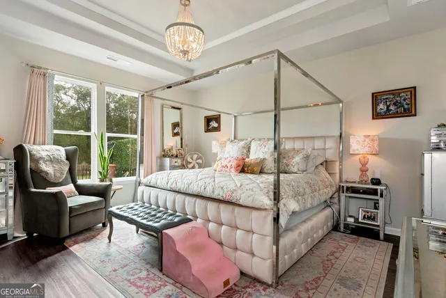 a bedroom with a bed couch and large window