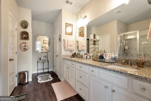 a bathroom with a granite countertop double vanity sink and a mirror
