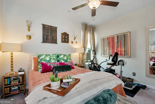 a bedroom with a bed potted plant on the dresser and a window