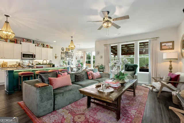 a living room with furniture kitchen view and a large window