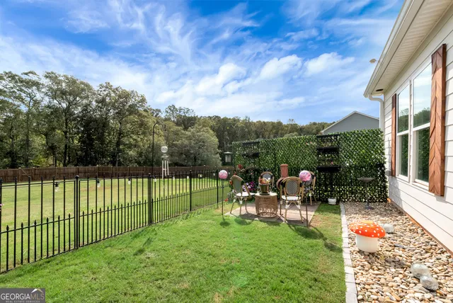 a view of a chairs and table in patio with a yard