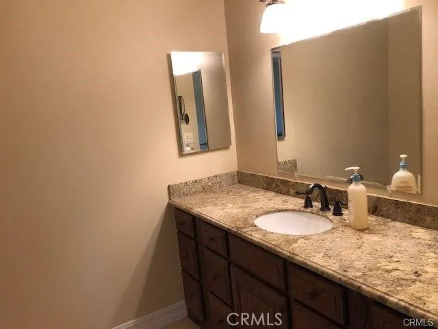 a bathroom with a granite countertop sink and a mirror