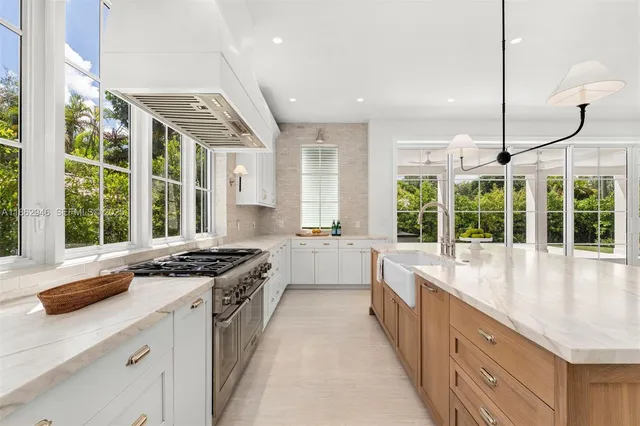a kitchen with a sink a counter top and a ceiling fan