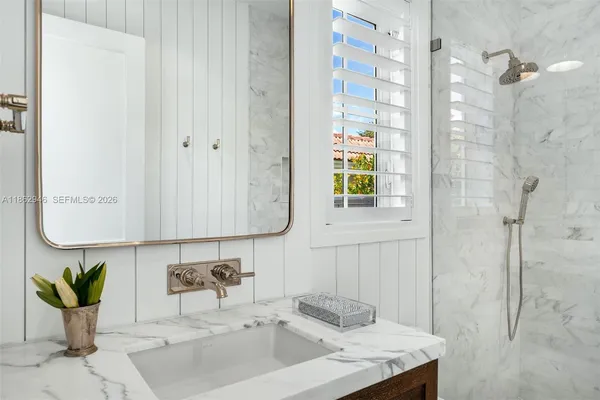 a bathroom with a granite countertop sink and a mirror