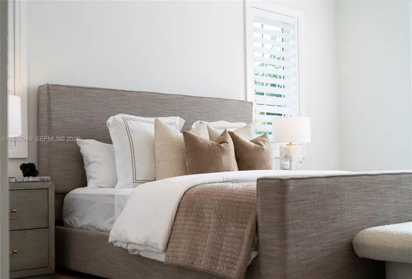 a bed sitting in a bedroom next to a window