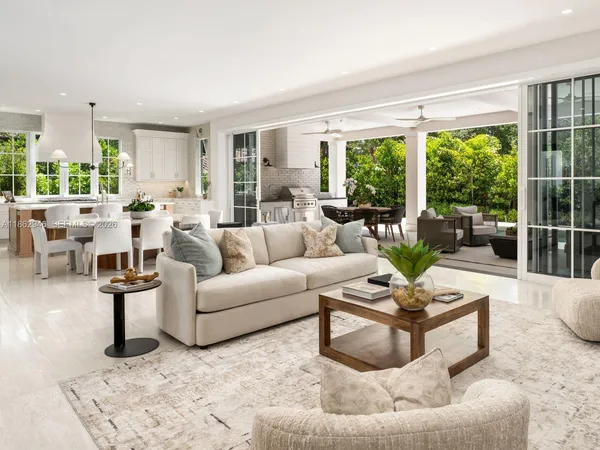 a kitchen with stainless steel appliances kitchen island granite countertop a table chairs and a refrigerator